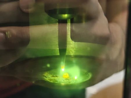 An electric arc melting a sample inside the arc melter's chamber.