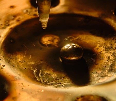 The fourth NdPtSi attempt, freshly melted: an even, silvery button with none of the earlier blackening.