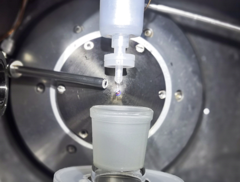 In the sample chamber, the NaK alloy drips from a nozzle. As the droplet grows, water vapour flows into the sample chamber and forms a thin skin on the drop's surface.