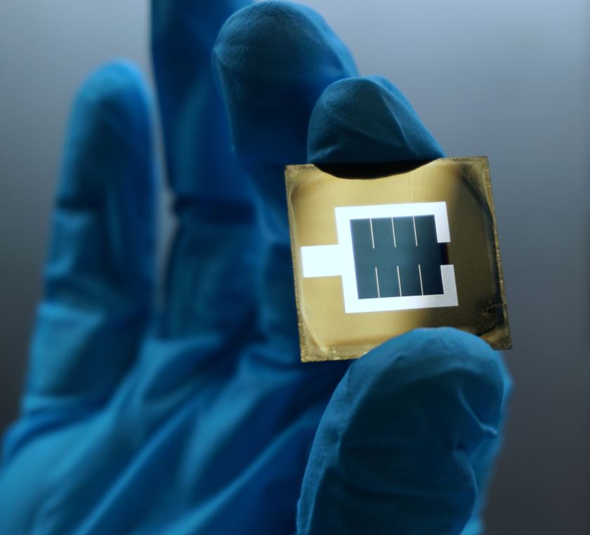 Photo of the perovskite/silicon tandem solar cell. You can see the active bluish area in the middle of the wafer, which is enclosed by the metallic, silvery electrode.