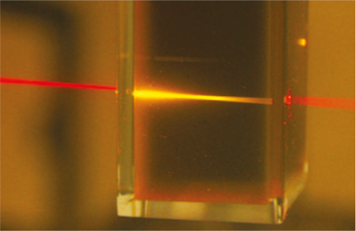 Rotes Licht eines Laserpointers wird beim Durchgang durch<br />die Fl&uuml;ssigkeit des photochemischen Hochkonverters in<br />energiereiches gelbes Licht umgewandelt.<br />Quelle: University of Sydney, Australien