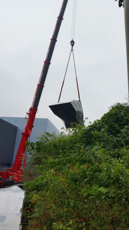 At first, the various parts are carefully unloaded so that they can be lifted quickly into the building through the roof of the NEAT building's newest addition.
