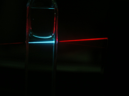 Die organischen Moleküle (hier in einer Kuvette) wandeln niedrigenergetische (rote) Photonen in höherenergetische ("blaue") Photonen um, die in eine Solarzelle zur Stromerzeugung beitragen können. 
