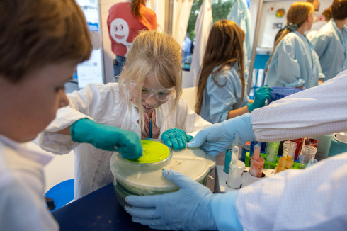 Children used a salad spinner to apply bright colours to a paper plate. The process in the lab is similar: scientists use spin coating to produce thin perovskite layers onto a substrate.