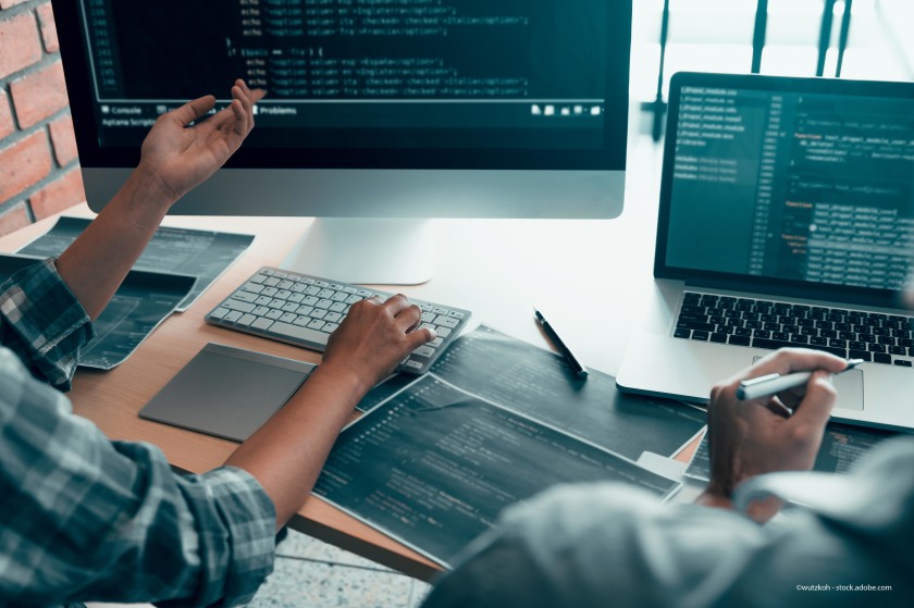 Computer screens with people in discussion in front of them